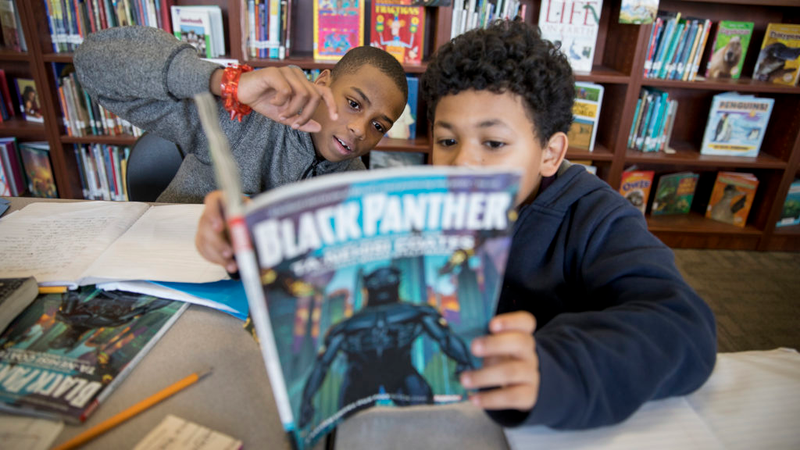 In Washington, D.C., fifth-graders Kemari Starks and Daymon Dimson discuss the Black Panther story as part of an increasingly popular all-boys book club at the Truesdell Education Campus. (Tyrone Turner/WAMU-FM)